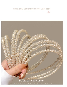 Close-up of elegant white pearl headband for girls showing the smooth texture and detail