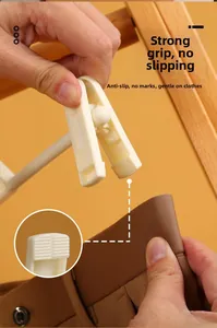 Detail of white non-slip pants hanger clip holding brown fabric without leaving marks