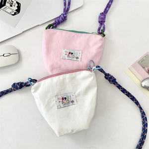 Detailed top view of pink and white nylon crossbody bags with colorful cord straps