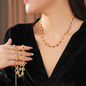 Gros plan sur un collier vintage doré avec pierre rouge et bracelet assorti