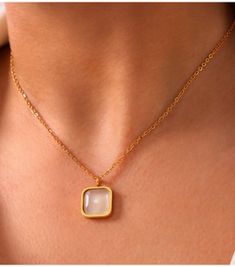 Detailed close-up of a vintage-style gold-plated necklace with a square resin pendant