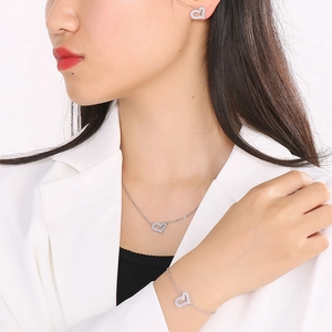 Dettaglio del set di gioielli a cuore asimmetrico con orecchini, collana e bracciale