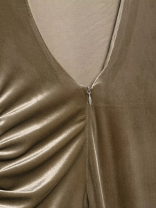 Détail de robe en velours marron avec col en V, plis élégants et fermeture éclair invisible