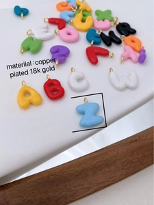 Makro-Detail bunter Buchstabenanhänger aus 18 Karat vergoldetem Kupfermaterial