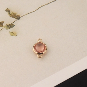 Detail of round pink crystal pendant with gold plating and double loops for jewelry making