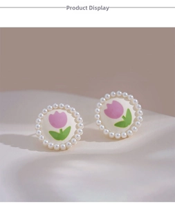 Detail of round clip-on earring featuring pink tulip motif and white pearl border