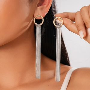 Detail of two-tone gold and silver long tassel earrings worn by a model