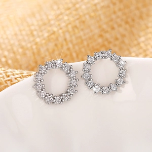 Macro shot of silver circular hollow stud earrings with sparkling zircon gemstones