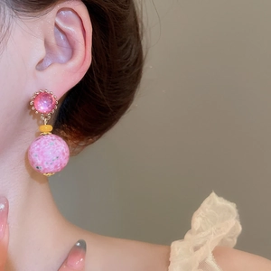 Side view of pink resin drop earrings with floral patterns worn for a vintage look