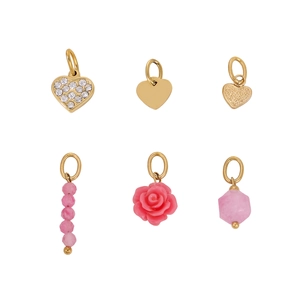 Close-up of six gold-plated heart and pink rose charms for jewelry making DIY