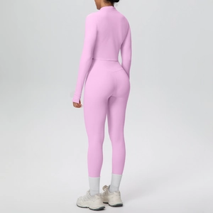 Dettaglio del retro del set con top corto rosa a maniche lunghe e leggings da yoga