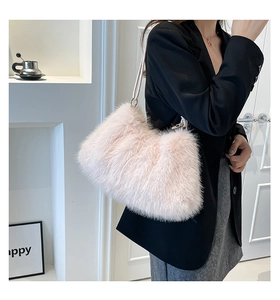 Détail du sac à bandoulière en fausse fourrure rose avec chaîne porté par un modèle