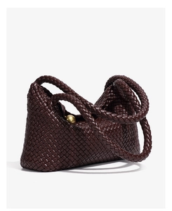 Macro detail of dark brown hand-woven leather tote with decorative gold metal sphere