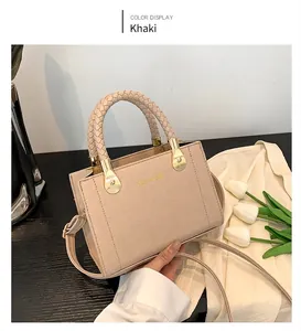 Détail du sac bandoulière kaki avec poignée tressée et texture de cuir litchi