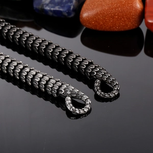 Vintage stainless steel cobra snake chain bracelet with textured scales on black surface
