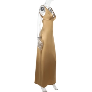 Detail of elegant gold satin dress with deep V-neck and delicate metallic chain straps