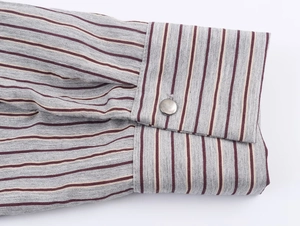 Detail of striped shirt cuff featuring a silver metal button and high-quality grey fabric