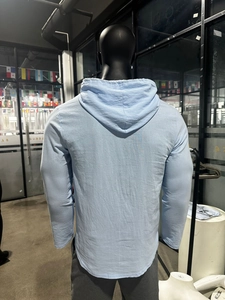 Rear view of light blue long-sleeve linen hooded shirt with curved hem on a male mannequin