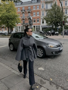 Détail d'un manteau en laine gris avec col montant et ceinture à la taille