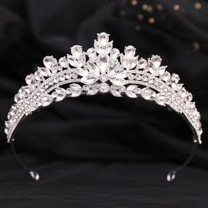 Close-up of elegant silver bridal crown with intricate rhinestone detailing on black background