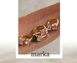 Detailed shot of gold-plated titanium steel rings with emerald and teardrop zircon stones