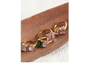 Detailed shot of gold-plated titanium steel rings with emerald and teardrop zircon stones