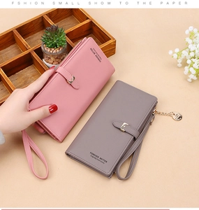 Detail of pink and taupe long leather wallets with wristlet straps and metal buckles