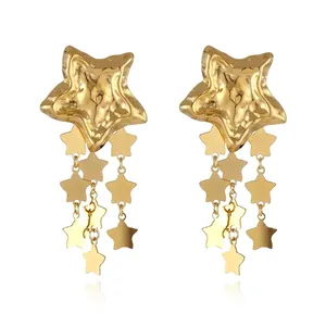 Detail of 18k gold plated star earrings featuring hammered textures and layered tassels