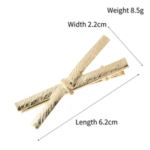 Golden metal bow hair clip with textured finish, dimensions 6.2cm long and 8.5g weight
