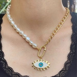 Evil eye necklace with gold chain and pearls, layered style pendant worn by model