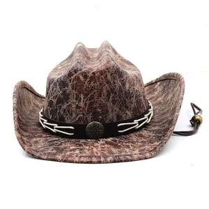 Detail of faux suede cowboy hat with cracked texture and bronze sun emblem band