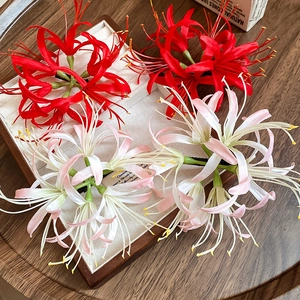 Detailed macro view of handmade red and pink Lycoris hair clips on a linen texture tray