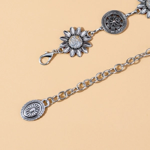 Detail of vintage silver waist chain featuring sunflower metal links and hollow round patterns
