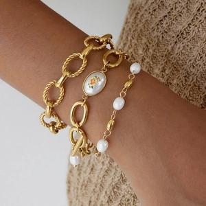 Ensemble de trois bracelets en acier titane doré avec perles d'eau douce et pendentif floral