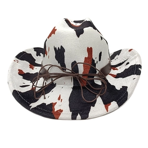 Detail of cow print cowboy hat showing brown faux leather cord and curved brim