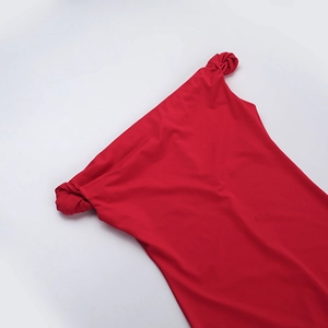 Detailed view of the elegant shoulder knot on a red off-the-shoulder fishtail maxi dress