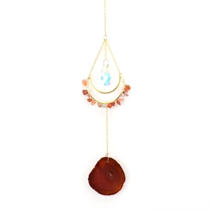 Detail of sun catcher with golden chain, colorful crystals and natural agate slice