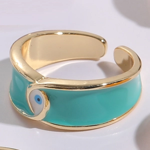 Detail of gold evil eye open ring with turquoise enamel and 14K finish texture