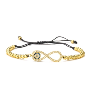 Detailed view of evil eye infinity symbol charm on 18K gold plated beaded bracelet