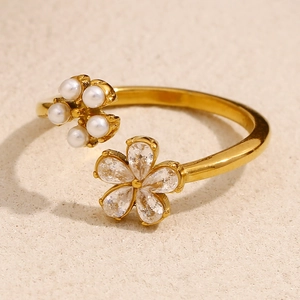 Macro shot of gold-plated flower ring featuring zircon petals and white pearl cluster detail