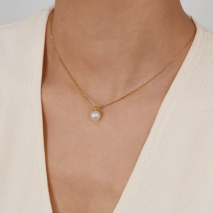 Elegant gold necklace for women featuring a minimalist round pearl pendant on a fine chain