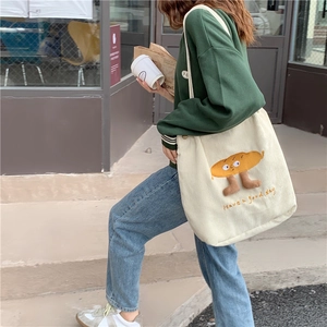Détail du sac cabas en velours côtelé crème avec broderie mignonne et vue de côté porté