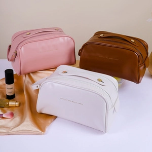 Three cosmetic bags in pink, brown and white with stone texture and silk background