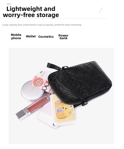 Détail d'une pochette noire en cuir PU avec motif camélia embossé et fermeture éclair