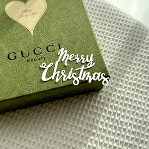 Close-up of green embossed GUCCI gift box with Happy Spring Time heart tag detail