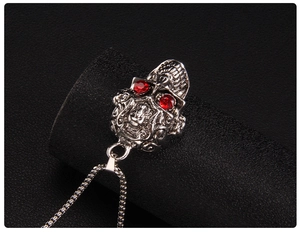 Vue détaillée du collier tête de mort punk avec yeux en pierres rouges sur fond noir