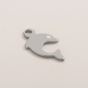 Polished silver stainless steel dolphin pendant with ring on light background