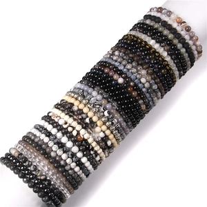 Macro shot of 8mm natural stone beads on bracelets showing texture and gold engravings