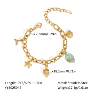 Detailed view of stainless steel charm bracelet with ocean pendants and green gemstone