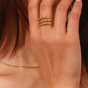 Close-up of three-layer spiral twisted 18K gold plated stainless steel ring on finger